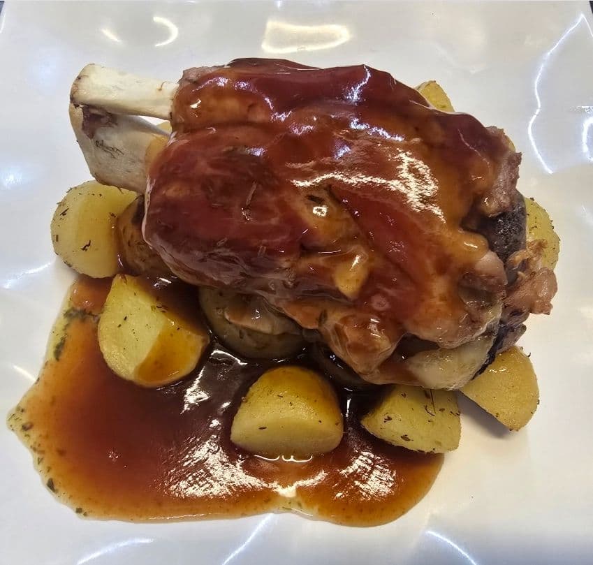 SCHWEINEHAXE MIT KARTOFFELN IN BUTTER